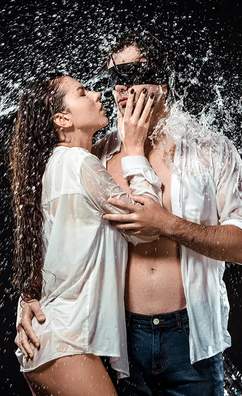a couple of lovers caressing in a shower of water